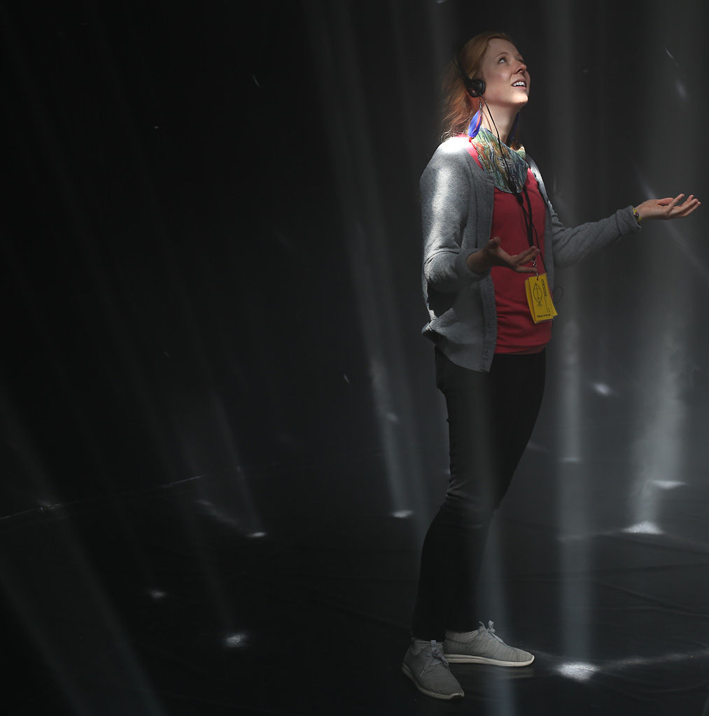 Marie Schaller reaches out to touches light beams